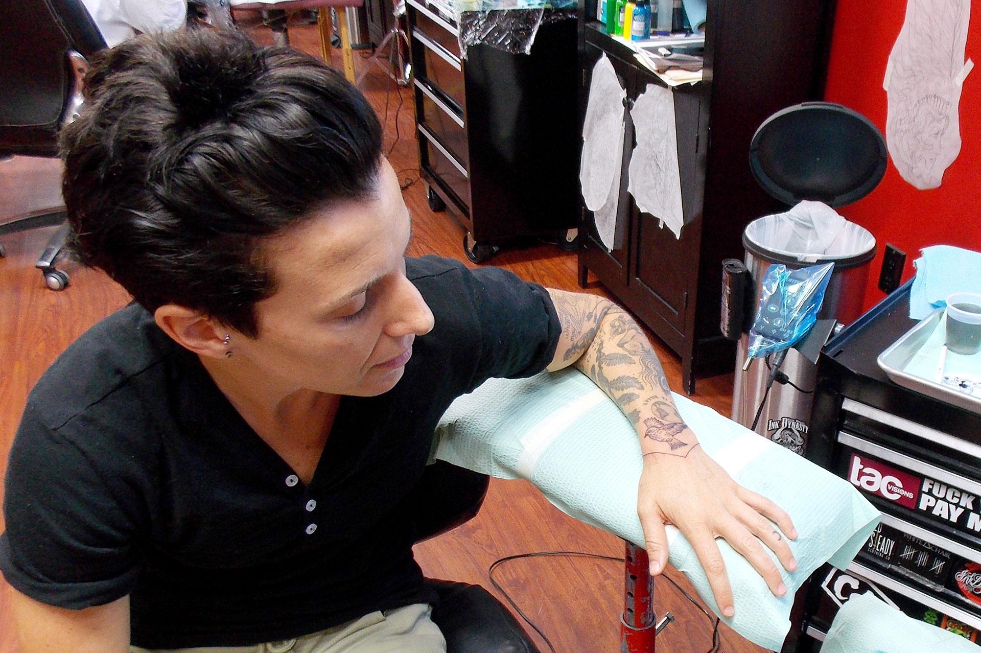 Renee Periat, CEO and founder of Androgynous Fox clothing line, examines the finalized version of her finch tattoo, created by Tattoo Artist Jake Schroeder on Oct. 11 at Keith Duggan’s Ink Dynasty. The tattoo took under half an hour altogether. The longest Schroeder has ever
spent tattooing in one sitting was about eight hours for a back piece.